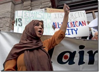 Community-advocate-Nimo-Yonis-leads-a-protest-chant-against-the-mayor-of-Lewiston-Maine.-300x219