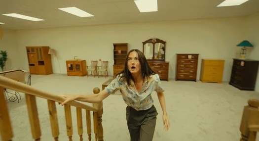 Woman climbing stairs in furniture store.