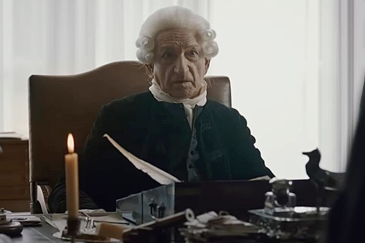 Ben Kingsley in a white wig looking perturbed.